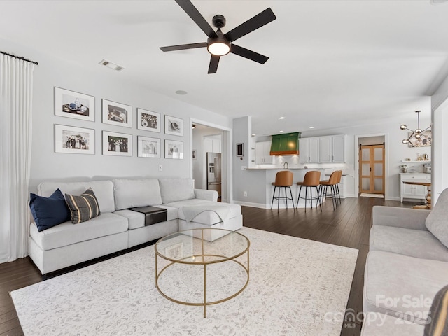 living room with dark wood-type flooring and ceiling fan