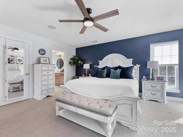 bedroom featuring light carpet, connected bathroom, and ceiling fan