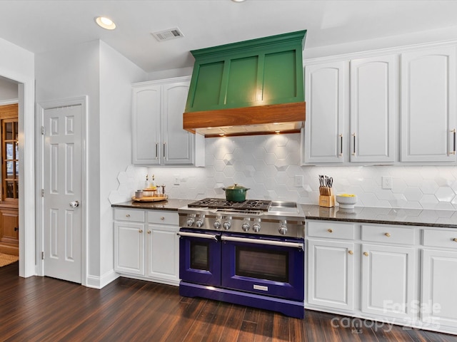 kitchen with range with two ovens, premium range hood, dark hardwood / wood-style floors, and white cabinets