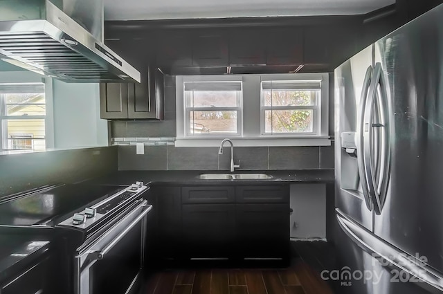 kitchen featuring sink, extractor fan, appliances with stainless steel finishes, dark hardwood / wood-style flooring, and decorative backsplash