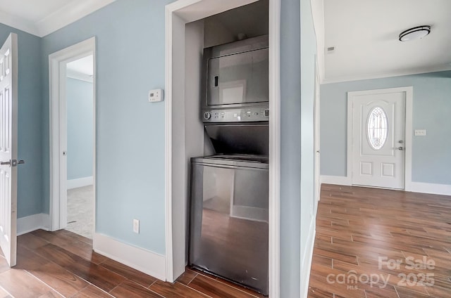 laundry area with ornamental molding and stacked washer and clothes dryer