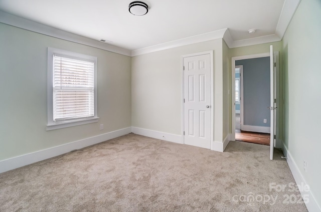 unfurnished bedroom featuring crown molding and light carpet