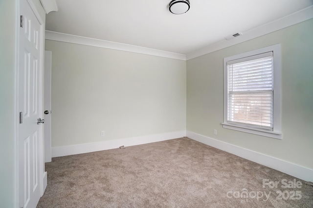 carpeted spare room featuring crown molding