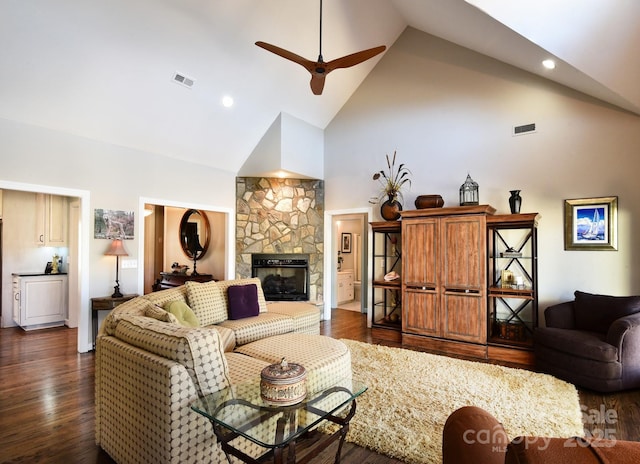 living room featuring ceiling fan, dark hardwood / wood-style floors, a fireplace, and high vaulted ceiling