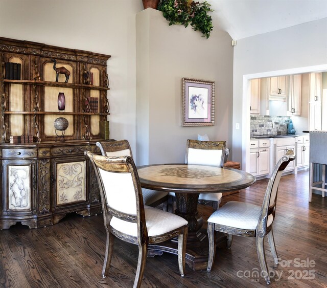 dining area featuring dark hardwood / wood-style flooring and lofted ceiling