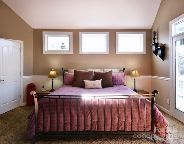 bedroom featuring multiple windows, vaulted ceiling, and carpet