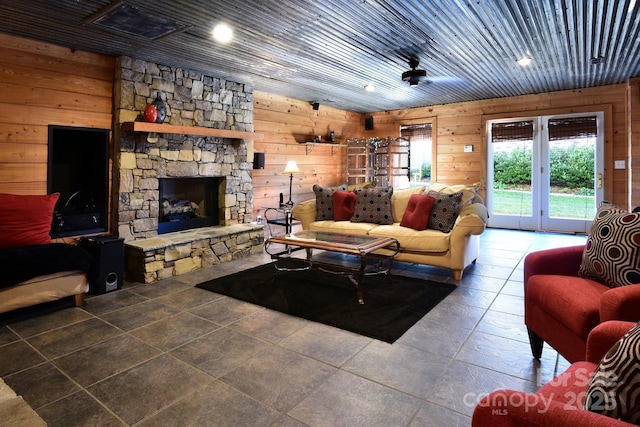 living room with tile patterned flooring, wood ceiling, a fireplace, and wood walls