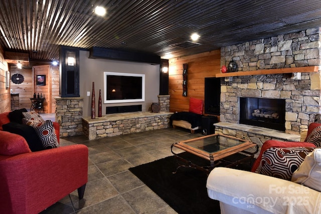 living room with a fireplace and wood walls