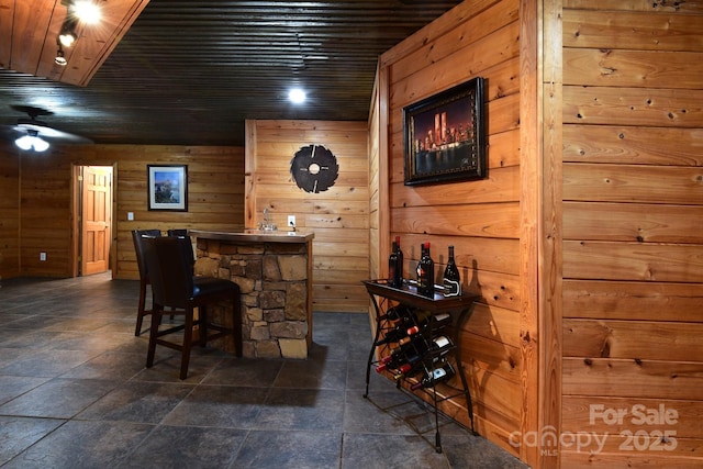 bar featuring wooden ceiling and wooden walls