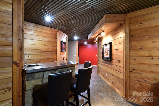 bar with wooden walls, sink, and wooden ceiling