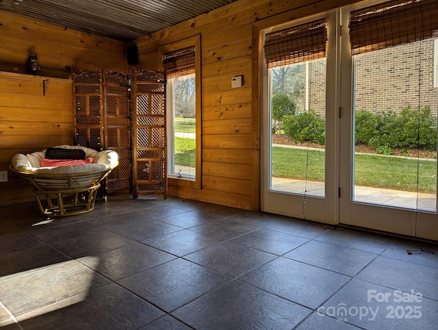 doorway to outside featuring a wealth of natural light and wood walls