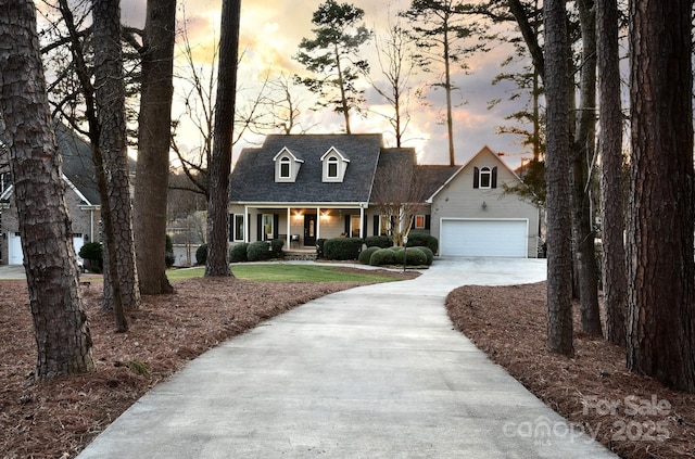 cape cod-style house with a porch and a garage