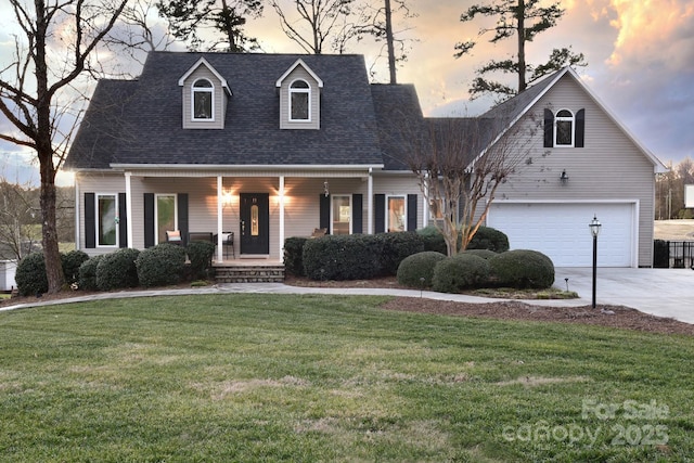 cape cod-style house with a garage, a lawn, and a porch