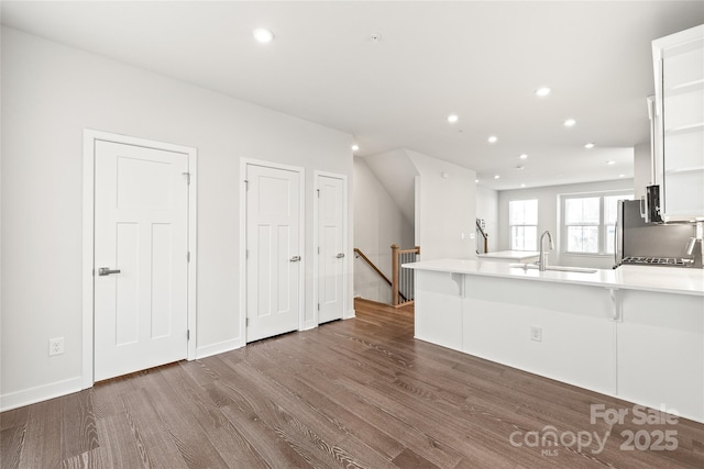 kitchen featuring sink, white cabinets, dark hardwood / wood-style flooring, and kitchen peninsula