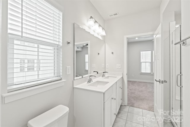 bathroom with vanity, a shower with shower door, toilet, and tile patterned flooring