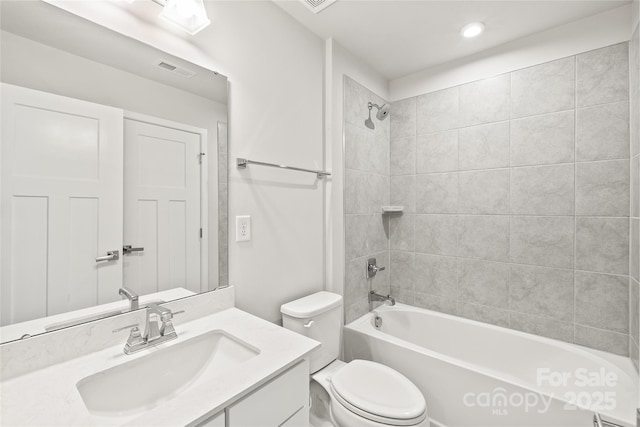 full bathroom featuring toilet, vanity, and tiled shower / bath