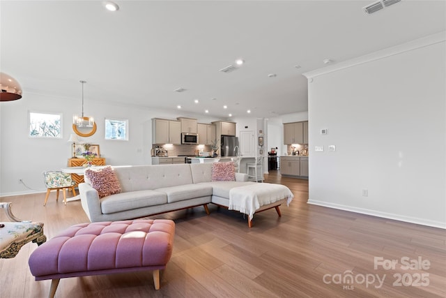 living room featuring light wood-style flooring, visible vents, and recessed lighting