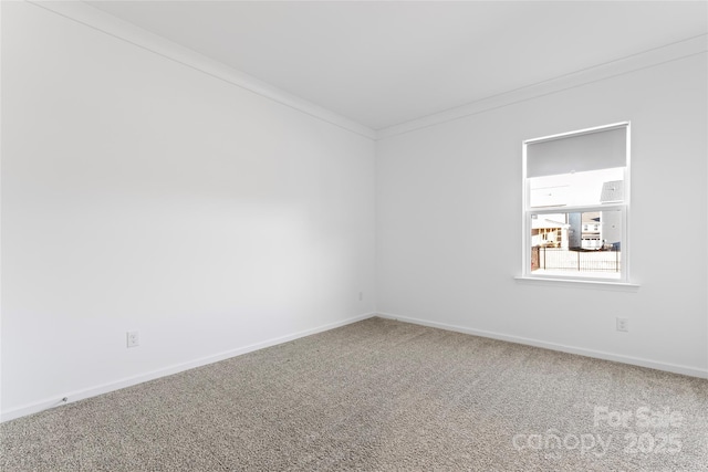 unfurnished room with carpet floors, ornamental molding, and baseboards