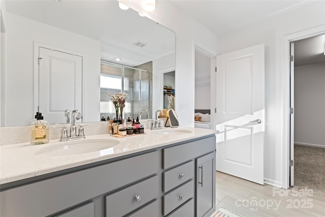 full bath with a stall shower, visible vents, a sink, and double vanity