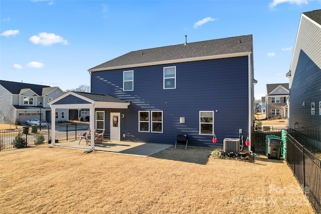 back of house featuring a fenced backyard, a lawn, central AC, and a patio