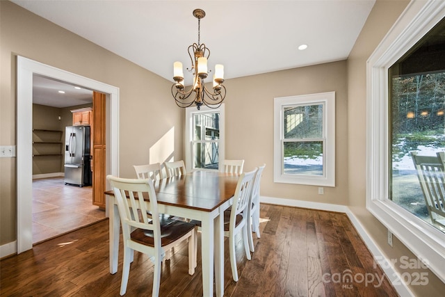 dining space featuring dark hardwood / wood-style flooring and a chandelier