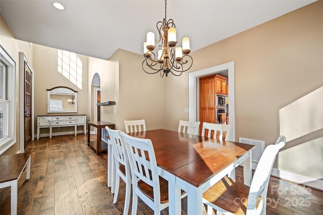 dining space with dark hardwood / wood-style floors and a chandelier