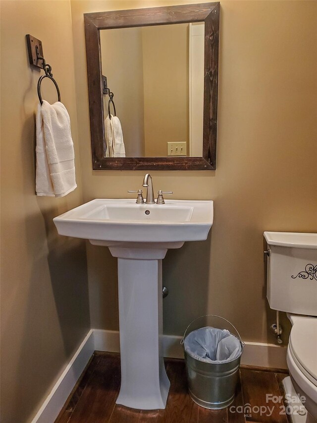 bathroom with hardwood / wood-style flooring and toilet