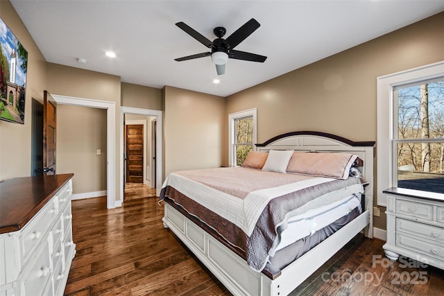 bedroom featuring multiple windows, dark wood-type flooring, and ceiling fan