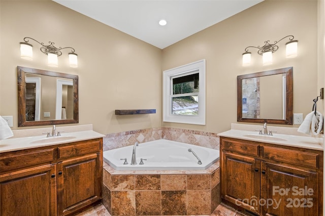 bathroom featuring vanity and tiled bath