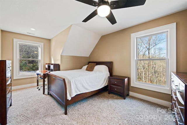 carpeted bedroom featuring multiple windows, vaulted ceiling, and ceiling fan