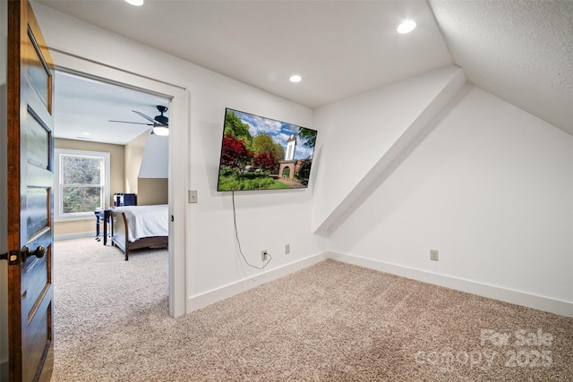 unfurnished bedroom with ceiling fan, carpet flooring, and vaulted ceiling