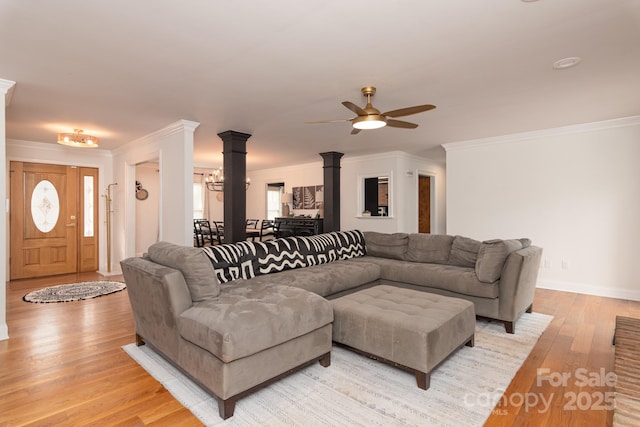 living room with crown molding, light hardwood / wood-style flooring, ceiling fan, and ornate columns