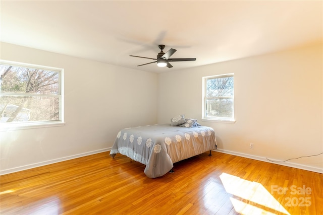 bedroom featuring ceiling fan, wood finished floors, and baseboards