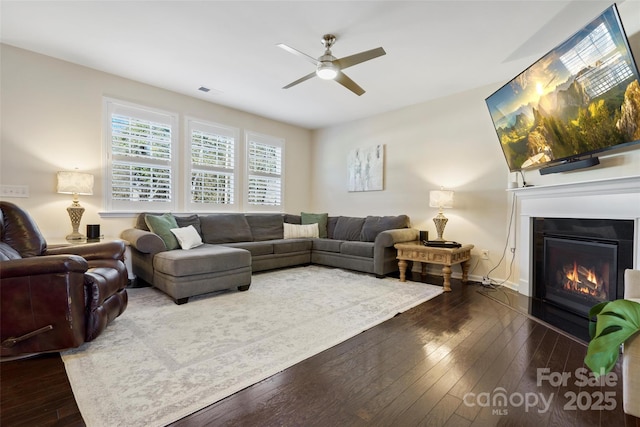 living room featuring ceiling fan and dark hardwood / wood-style flooring