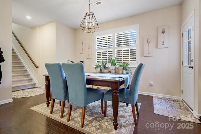 dining area with an inviting chandelier and dark hardwood / wood-style flooring