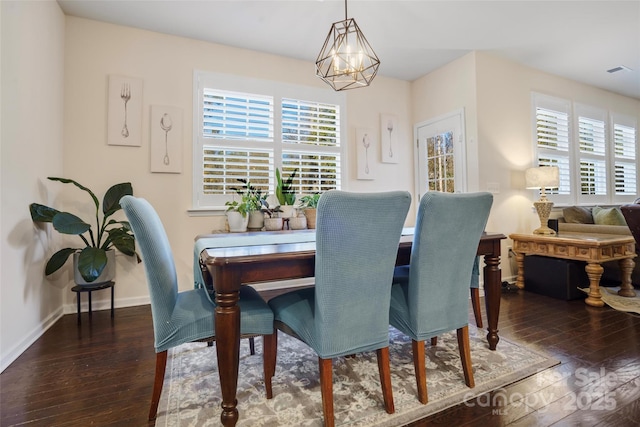 dining space with a chandelier and dark hardwood / wood-style flooring