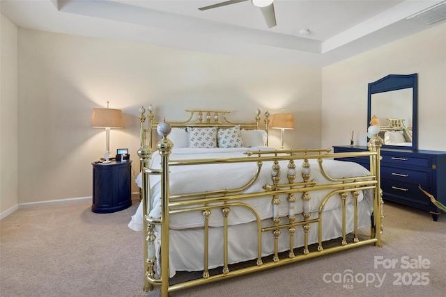 bedroom featuring ceiling fan, a tray ceiling, and light colored carpet