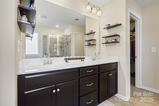 bathroom featuring tile patterned floors, a shower with door, and vanity