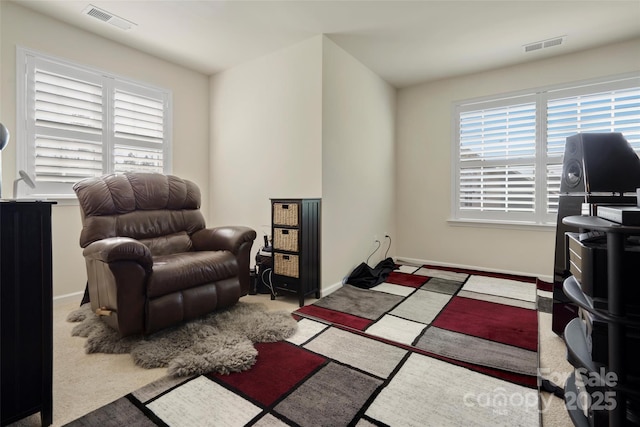 sitting room with plenty of natural light and light colored carpet