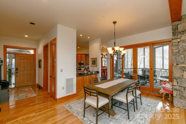 dining room with a chandelier and light wood-type flooring