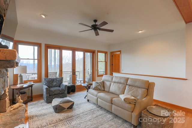 living room with plenty of natural light, light hardwood / wood-style floors, and french doors