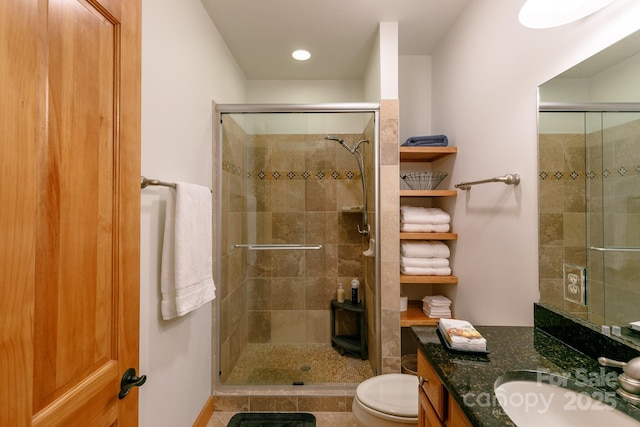 bathroom with toilet, vanity, and walk in shower