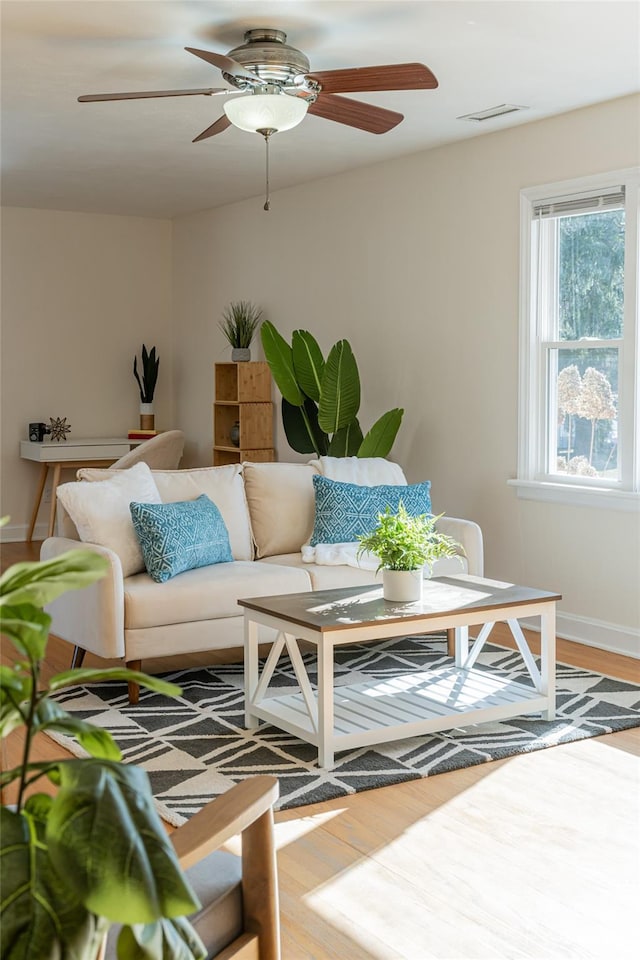 living room featuring hardwood / wood-style floors and ceiling fan