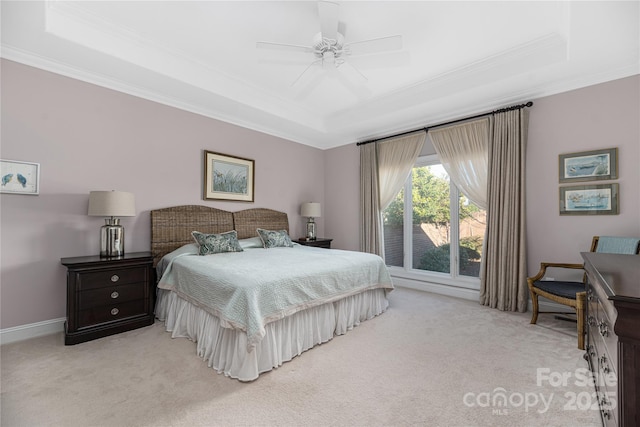 carpeted bedroom featuring crown molding, a tray ceiling, and ceiling fan