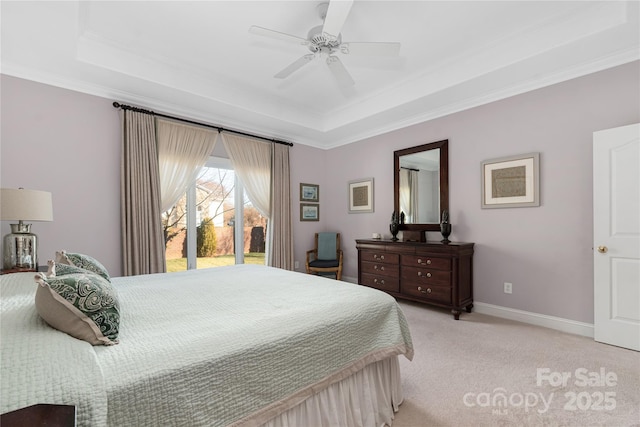 carpeted bedroom featuring crown molding, a tray ceiling, and ceiling fan