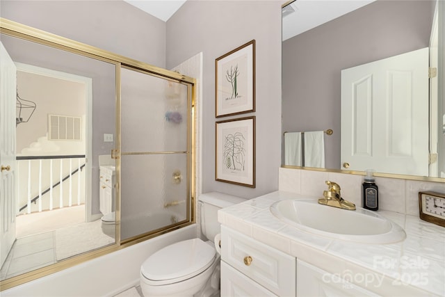 full bathroom with vanity, toilet, and combined bath / shower with glass door