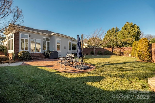 back of house featuring a lawn and a patio area