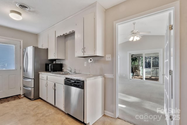 kitchen featuring a sink, stainless steel appliances, light countertops, and white cabinetry