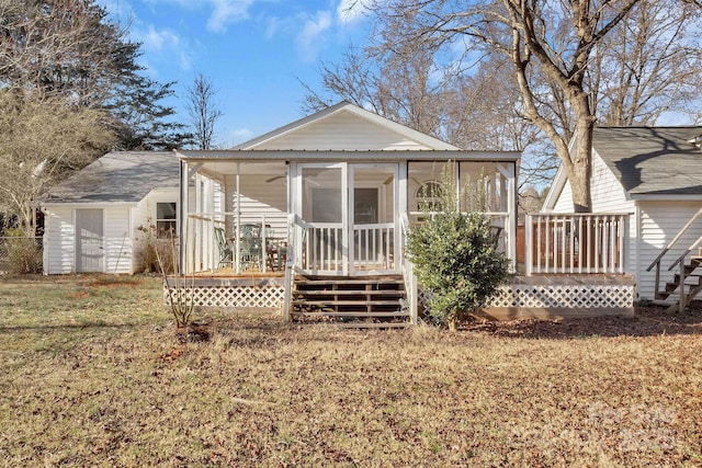 rear view of house featuring a sunroom, stairs, a deck, and a yard