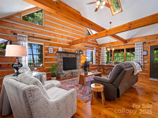 living room featuring beamed ceiling, light hardwood / wood-style flooring, high vaulted ceiling, and a stone fireplace